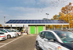 Elektroautos auf Parkplatz vor Bushaltestelle mit Aufdach-Photovoltaik